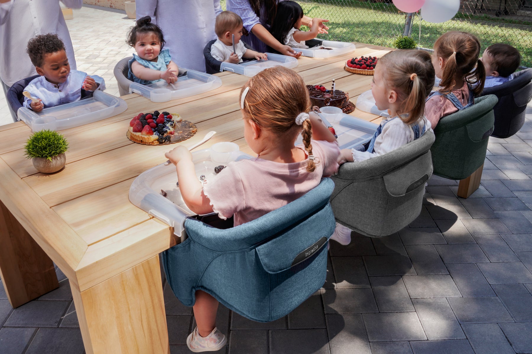 Children enjoying snacks while seated in Inglesina Fast Table Chairs at a table.